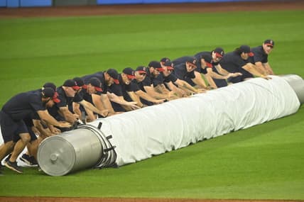 Aug 23, 2023; Cleveland, Ohio, USA; The Cleveland Guardians grounds crew unrolls the tarp on the field during a rain delay after the second inning against the Los Angeles Dodgers at Progressive Field. Mandatory Credit: David Richard-USA TODAY Sports