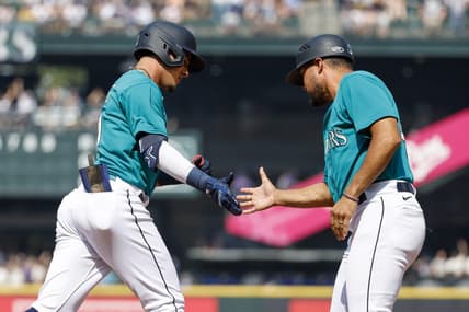 Aug 28, 2023; Seattle, Washington, USA; Seattle Mariners second baseman Josh Rojas (4, left) shakes hands with first base coach Kristopher Negr  n (45) after hitting a solo-home run against the Kansas City Royals during the third inning at T-Mobile Park. Mandatory Credit: Joe Nicholson-USA TODAY Sports