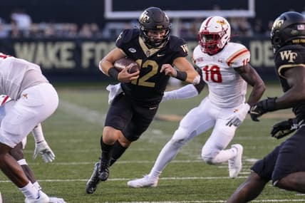 Sep 1, 2022; Winston-Salem, North Carolina, USA; Wake Forest Demon Deacons quarterback Mitch Griffis (12) runs past Virginia Military Institute Keydets linebacker Jason Johnson (18) during the first half at Truist Field. Mandatory Credit: Jim Dedmon-USA TODAY Sports