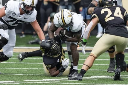 Sep 9, 2023; Winston-Salem, North Carolina, USA; Vanderbilt Commodores running back Patrick Smith (4) is tackled by Wake Forest Demon Deacons defensive lineman Jasheen Davis (30) during the first quarter at Allegacy Federal Credit Union Stadium. Mandatory Credit: Jim Dedmon-USA TODAY Sports