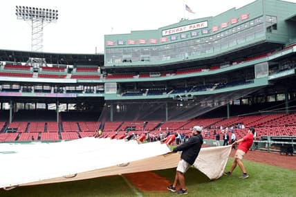 Sep 11, 2023; Boston, Massachusetts, USA; The grounds crew covers the infield with a tarp before a game between the New York Yankees and the Boston Red Sox  at Fenway Park. Mandatory Credit: Brian Fluharty-USA TODAY Sports