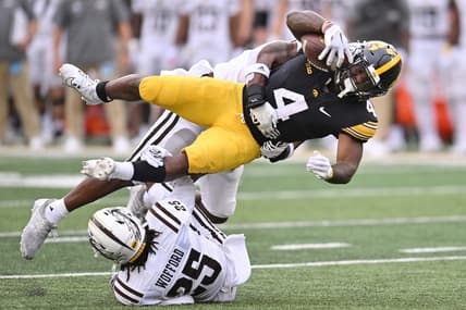 Sep 16, 2023; Iowa City, Iowa, USA; Iowa Hawkeyes running back Leshon Williams (4) runs the ball as Western Michigan Broncos cornerback Aaron Wofford (25) and linebacker Damari Roberson (rear) make the tackle during the first quarter at Kinnick Stadium. Mandatory Credit: Jeffrey Becker-USA TODAY Sports