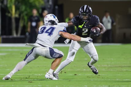 Sep 16, 2023; Orlando, Florida, USA; UCF Knights wide receiver Kobe Hudson (2) runs the ball as Villanova Wildcats defensive back Ethan Potter (34) moves in during the second quarter at FBC Mortgage Stadium. Mandatory Credit: Mike Watters-USA TODAY Sports