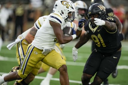 Sep 23, 2023; Winston-Salem, North Carolina, USA;  Georgia Tech Yellow Jackets running back Trey Cooley (0) runs the ball against Wake Forest Demon Deacons defensive lineman Kevin Pointer (91) during the first half at Allegacy Federal Credit Union Stadium. Mandatory Credit: Jim Dedmon-USA TODAY Sports