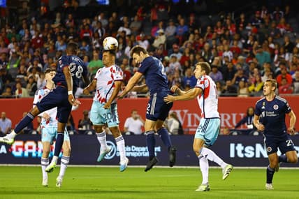 Sep 23, 2023; Chicago, Illinois, USA; Chicago Fire midfielder Jairo Torres (20) heads the ball against New England Revolution defender Dave Romney (2) during the first half at Soldier Field. Mandatory Credit: Mike Dinovo-USA TODAY Sports