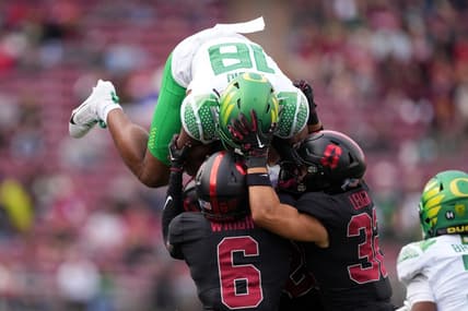 Sep 30, 2023; Stanford, California, USA; Oregon Ducks tight end Kenyon Sadiq (18) attempts to leap over Stanford Cardinal cornerback Collin Wright (6) and safety Mitch Leigber (32) during the second quarter at Stanford Stadium. Mandatory Credit: Darren Yamashita-USA TODAY Sports