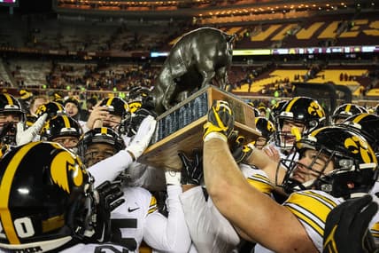 Nov 19, 2022; Minneapolis, Minnesota, USA; Iowa Hawkeyes players celebrate with the Floyd of Rosedale after defeating the Minnesota Golden Gophers at Huntington Bank Stadium. Mandatory Credit: Matt Krohn-USA TODAY Sports