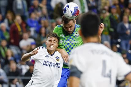 Oct 4, 2023; Seattle, Washington, USA; Seattle Sounders FC forward Jordan Morris (13, right) heads a cross against Los Angeles Galaxy defender Julian Aude (3) during the first half at Lumen Field. Mandatory Credit: Joe Nicholson-USA TODAY Sports