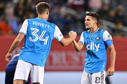 Oct 7, 2023; Chicago, Illinois, USA;  Charlotte FC midfielder Andrew Privett (34) and midfielder Ashley Westwood (8) celebrate after a victory over the Chicago Fire FC at Soldier Field. Mandatory Credit: Jamie Sabau-USA TODAY Sports