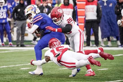 Oct 28, 2023; Lawrence, Kansas, USA; Kansas Jayhawks running back Devin Neal (4) runs the ball as Oklahoma Sooners linebacker Danny Stutsman (28) and defensive back Kendel Dolby (15) make the tackle during the first half at David Booth Kansas Memorial Stadium. Mandatory Credit: Denny Medley-USA TODAY Sports