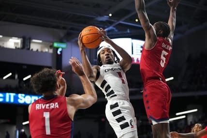 Cincinnati Bearcats guard Day Day Thomas (1) rises to the basket as Illinois-Chicago Flames guard Toby Okani (5) and Illinois-Chicago Flames guard Isaiah Rivera (1) defend in the first half of a men   s college basketball game between the Illinois-Chicago Flames and the Cincinnati Bearcats, Monday, Nov. 6, 2023, at Fifth Third Arena in Cincinnati.