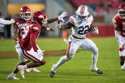 Nov 11, 2023; Fayetteville, Arkansas, USA;  Auburn Tigers running back Damari Alston (22) tries to fight off Arkansas Razorbacks defensive back TJ Metcalf (18) during the third quarter at Donald W. Reynolds Razorback Stadium. Auburn won 48-10. Mandatory Credit: Brett Rojo-USA TODAY Sports