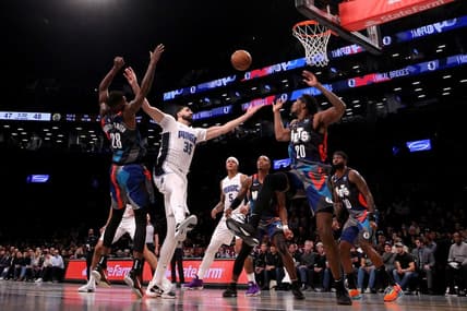Nov 14, 2023; Brooklyn, New York, USA; Orlando Magic center Goga Bitadze (35) fights for a rebound against Brooklyn Nets forward Dorian Finney-Smith (28) and center Day'Ron Sharpe (20) during the second quarter at Barclays Center. Mandatory Credit: Brad Penner-USA TODAY Sports