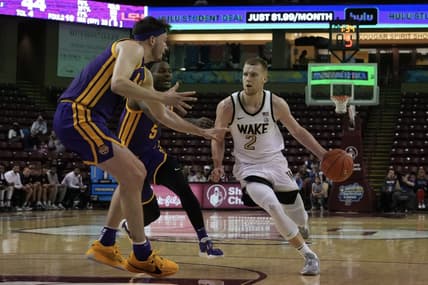 Nov 19, 2023; Charleston, SC, USA; Wake Forest Demon Deacons guard Cameron Hildreth (2) drives the ball around LSU Tigers forward Will Baker (9) in the first half at TD Arena. Mandatory Credit: David Yeazell-USA TODAY Sports
