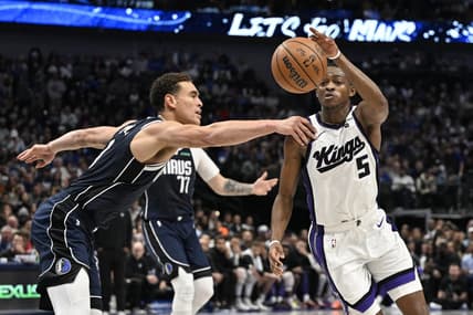 Nov 19, 2023; Dallas, Texas, USA;Dallas Mavericks center Dwight Powell (7) and Sacramento Kings guard De'Aaron Fox (5) battle for control of a loose ball during the second quarter at the American Airlines Center. Mandatory Credit: Jerome Miron-USA TODAY Sports