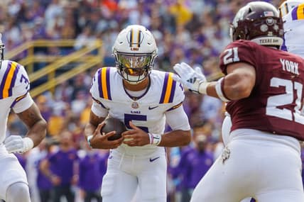 Nov 25, 2023; Baton Rouge, Louisiana, USA;  LSU Tigers quarterback Jayden Daniels (5) rushes against Texas A&M Aggies linebacker Taurean York (21) during the first half at Tiger Stadium. Mandatory Credit: Stephen Lew-USA TODAY Sports