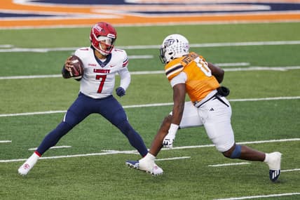 Nov 25, 2023; El Paso, Texas, USA; No. 22 Liberty Flames quarterback Kaidon Salter (7) tries to evade a UTEP Miners defensive end Maurice Westmoreland (0) during the first half at Sun Bowl Stadium. Mandatory Credit: Ivan Pierre Aguirre-USA TODAY Sports