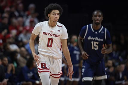 Nov 27, 2023; Piscataway, New Jersey, USA;  Rutgers Scarlet Knights guard Derek Simpson (0) reacts after making a three point basket in front of St. Peter's Peacocks forward Stephon Roberts (15) during the first half at Jersey Mike's Arena. Mandatory Credit: Vincent Carchietta-USA TODAY Sports