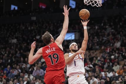 Nov 29, 2023; Toronto, Ontario, CAN; Phoenix Suns guard Devin Booker (1) shoots the ball as Toronto Raptors center Jakob Poeltl (19) defends during the first half at Scotiabank Arena. Mandatory Credit: John E. Sokolowski-USA TODAY Sports