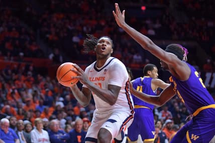Nov 24, 2023; Champaign, Illinois, USA;  Illinois Fighting Illini forward Dain Dainja (42) drives to the basket as Western Illinois Leathernecks center Drew Cisse (23) defends during the first half at State Farm Center. Mandatory Credit: Ron Johnson-USA TODAY Sports