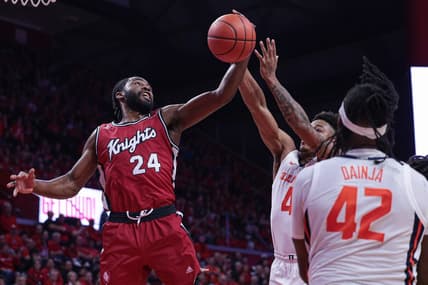 Dec 2, 2023; Piscataway, New Jersey, USA; Rutgers Scarlet Knights guard Austin Williams (24) rebounds against Illinois Fighting Illini guard Justin Harmon (4) and  forward Dain Dainja (42) during the first half at Jersey Mike's Arena. Mandatory Credit: Vincent Carchietta-USA TODAY Sports