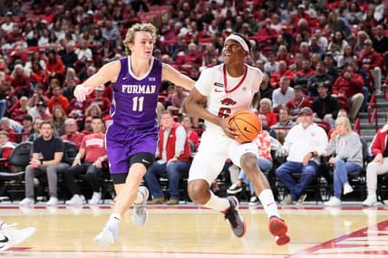 Dec 4, 2023; Fayetteville, Arkansas, USA; Arkansas Razorbacks guard Layden Blocker (6) drives against Furman Paladins guard Carter Whitt (11) during the first half at Bud Walton Arena. Mandatory Credit: Nelson Chenault-USA TODAY Sports