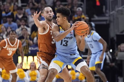 Dec 6, 2023; Milwaukee, Wisconsin, USA;  Marquette Golden Eagles forward Oso Ighodaro (13) looks to pass the ball under pressure from Texas Longhorns forward Brock Cunningham (30) during the first half at Fiserv Forum. Mandatory Credit: Jeff Hanisch-USA TODAY Sports