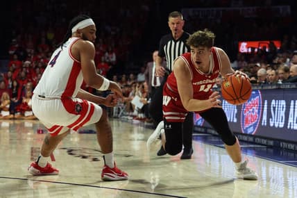 Dec 9, 2023; Tucson, Arizona, USA; Wisconsin Badgers guard Max Klesmit (11) drives to the net against Arizona Wildcats guard Kylan Boswell (4) during the first half at McKale Center. Mandatory Credit: Zachary BonDurant-USA TODAY Sports