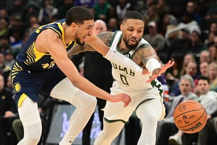 Dec 13, 2023; Milwaukee, Wisconsin, USA; Indiana Pacers guard Tyrese Haliburton (0) and Milwaukee Bucks guard Damian Lillard (0) reach for a loose ball in the first quarter at Fiserv Forum. Mandatory Credit: Benny Sieu-USA TODAY Sports