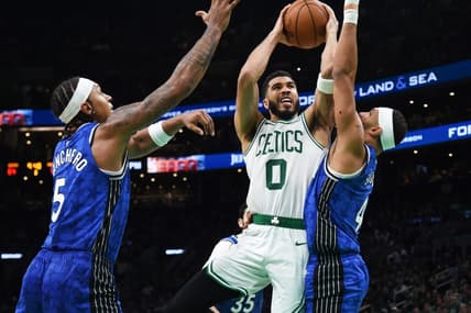 Dec 17, 2023; Boston, Massachusetts, USA;  Boston Celtics forward Jayson Tatum (0) drives to the basket between Orlando Magic forward Paolo Banchero (5) and guard Jalen Suggs (4) during the second half at TD Garden. Mandatory Credit: Bob DeChiara-USA TODAY Sports
