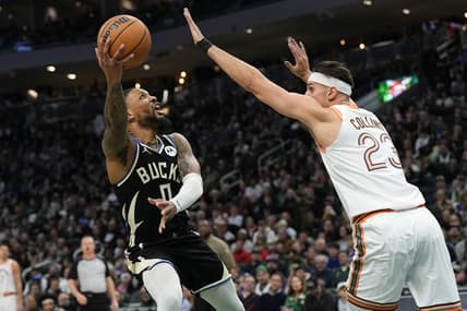 Dec 19, 2023; Milwaukee, Wisconsin, USA;  Milwaukee Bucks guard Damian Lillard (0) shoots around San Antonio Spurs center Zach Collins (23) during the first quarter at Fiserv Forum. Mandatory Credit: Jeff Hanisch-USA TODAY Sports