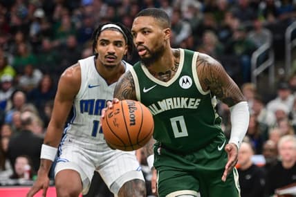 Dec 21, 2023; Milwaukee, Wisconsin, USA;  Milwaukee Bucks guard Damian Lillard (0) drives past Orlando Magic guard Gary Harris (14) in the fourth quarter at Fiserv Forum. Mandatory Credit: Benny Sieu-USA TODAY Sports