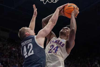 Dec 22, 2023; Lawrence, Kansas, USA; Kansas Jayhawks forward K.J. Adams Jr. (24) shoots and is fouled by Yale Bulldogs forward Nick Townsend (42) during the second half at Allen Fieldhouse. Mandatory Credit: Denny Medley-USA TODAY Sports