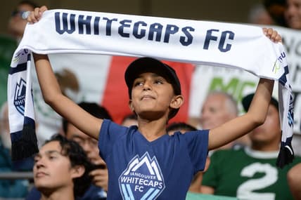 Jul 21, 2023; Vancouver, British Columbia, CAN; A young Vancouver Whitecaps fan is seen holding a scarf during the second half between the Vancouver Whitecaps and Club Leon at BC Place. Mandatory Credit: Anne-Marie Sorvin-USA TODAY Sports