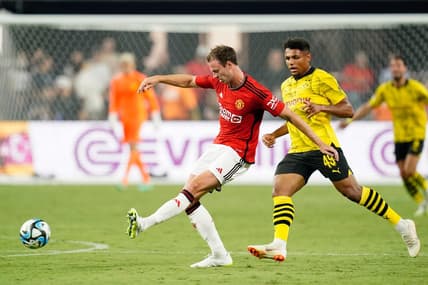 Jul 30, 2023; Las Vegas, Nevada, USA; Manchester United defender Jonny Evans (27) kicks the ball against Borussia Dortmund forward Paul-Phillip Besong (49) during the second half at Allegiant Stadium. Mandatory Credit: Lucas Peltier-USA TODAY Sports