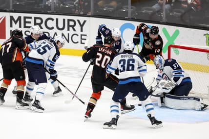 Dec 10, 2023; Anaheim, California, USA;  Winnipeg Jets goaltender Connor Hellebuyck (37) defends the goal against Anaheim Ducks right wing Brett Leason (20) during the third period at Honda Center. Mandatory Credit: Kiyoshi Mio-USA TODAY Sports