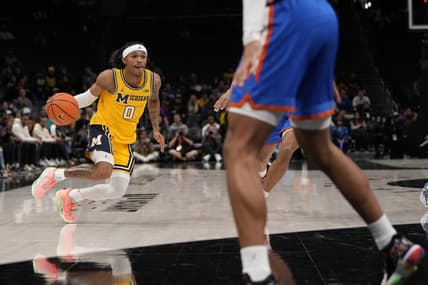 Dec 19, 2023; Charlotte, North Carolina, USA; Michigan Wolverines guard Dug McDaniel (0) drives to the basket against the Florida Gators during the first half at Spectrum Center. Mandatory Credit: Jim Dedmon-USA TODAY Sports