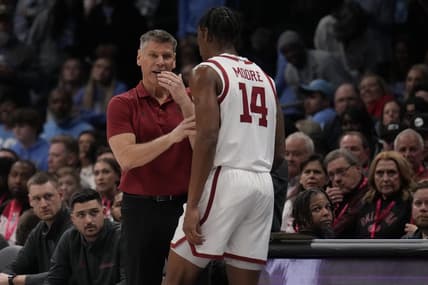 Dec 20, 2023; Charlotte, North Carolina, USA; Oklahoma Sooners head coach Porter Moser talks with forward Jalon Moore (14) during a time out against the North Carolina Tar Heels during the first half at Spectrum Center. Mandatory Credit: Jim Dedmon-USA TODAY Sports