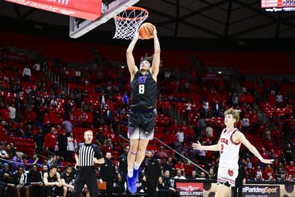 Dec 31, 2023; Salt Lake City, Utah, USA; Washington Huskies guard Nate Calmese (8) dunks over Utah Utes guard Cole Bajema (2) during the second half at the the Jon M. Huntsman Center. Mandatory Credit: Christopher Creveling-USA TODAY Sports