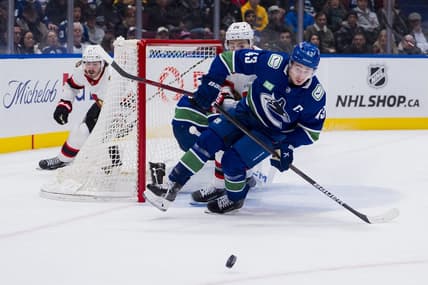 Jan 2, 2024; Vancouver, British Columbia, CAN; Ottawa Senators defenseman Erik Brannstrom (26) and Vancouver Canucks defenseman Quinn Hughes (43) skates after the loose puck in the second period at Rogers Arena. Mandatory Credit: Bob Frid-USA TODAY Sports