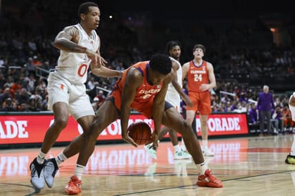 Jan 3, 2024; Coral Gables, Florida, USA; Clemson Tigers forward RJ Godfrey (10) protects the basketball from Miami Hurricanes guard Matthew Cleveland (0) during the first half at Watsco Center. Mandatory Credit: Sam Navarro-USA TODAY Sports