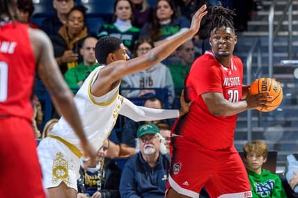 Jan 3, 2024; South Bend, Indiana, USA; North Carolina State Wolfpack forward DJ Burns, Jr. (30) looks to pass as Notre Dame Fighting Irish forward Kebba Njie (14) defends in the first half at the Purcell Pavilion. Mandatory Credit: Matt Cashore-USA TODAY Sports