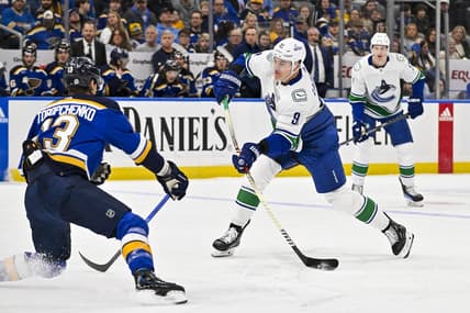 Jan 4, 2024; St. Louis, Missouri, USA;  Vancouver Canucks defenseman Nikita Zadorov (91) shoots as St. Louis Blues right wing Alexey Toropchenko (13) defends during the first period at Enterprise Center. Mandatory Credit: Jeff Curry-USA TODAY Sports