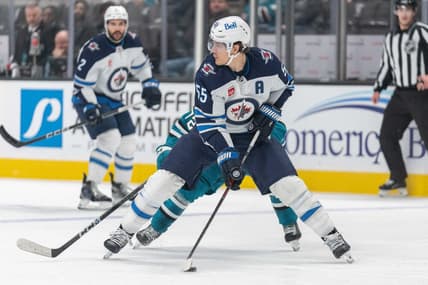 Jan 4, 2024; San Jose, California, USA;s Winnipeg Jets center Mark Scheifele (55) controls the puck during the second period against San Jose Sharks left wing William Eklund (72) at SAP Center at San Jose. Mandatory Credit: Stan Szeto-USA TODAY Sports