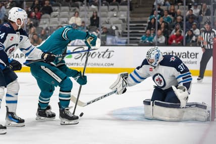 Jan 4, 2024; San Jose, California, USA; Winnipeg Jets goaltender Connor Hellebuyck (37) defends against San Jose Sharks defenseman Mario Ferraro (38) during the second period at SAP Center at San Jose. Mandatory Credit: Stan Szeto-USA TODAY Sports