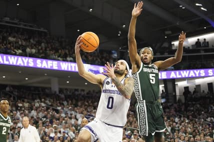 Jan 7, 2024; Evanston, Illinois, USA; Michigan State Spartans guard Tre Holloman (5) defends Northwestern Wildcats guard Boo Buie (0) during the second half at Welsh-Ryan Arena. Mandatory Credit: David Banks-USA TODAY Sports