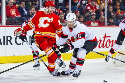 Jan 9, 2024; Calgary, Alberta, CAN; Calgary Flames center Elias Lindholm (28) passes the puck with his skate against Ottawa Senators defenseman Jakob Chychrun (6) during the second period at Scotiabank Saddledome. Mandatory Credit: Sergei Belski-USA TODAY Sports