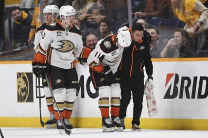 Jan 9, 2024; Nashville, Tennessee, USA; Anaheim Ducks center Trevor Zegras (11) is helped off the ice after an injury first period against the Nashville Predators at Bridgestone Arena. Mandatory Credit: Christopher Hanewinckel-USA TODAY Sports