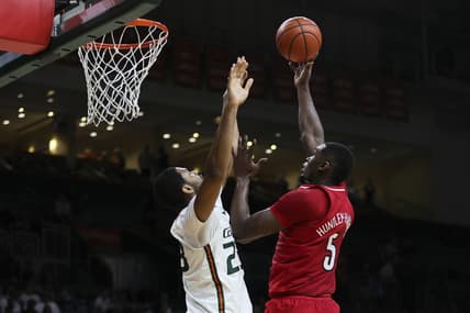 Jan 10, 2024; Coral Gables, Florida, USA; Louisville Cardinals forward Brandon Huntley-Hatfield (5) shoots the basketball over Miami Hurricanes forward AJ Casey (23) during the first half at Watsco Center. Mandatory Credit: Sam Navarro-USA TODAY Sports