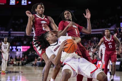 Jan 10, 2024; Athens, Georgia, USA; Georgia Bulldogs guard Silas Demary Jr. (4) controls the ball against Arkansas Razorbacks forward Chandler Lawson (8) and guard Keyon Menifield Jr. (1) during the first half at Stegeman Coliseum. Mandatory Credit: Dale Zanine-USA TODAY Sports